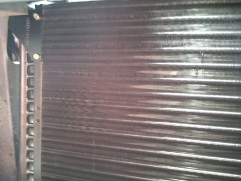 1994 Ford Bronco - Close-up of a car's AC condenser unit, showing the fins and a date stamp.