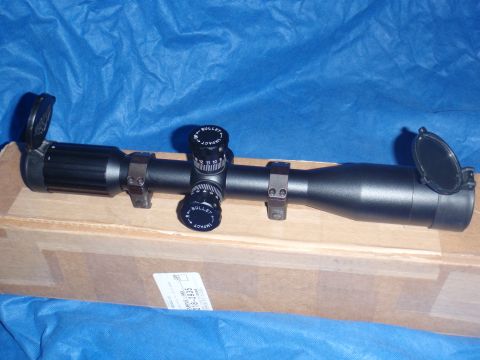 1991 Ford Bronco - Rifle scope with adjustment turrets and lens caps visible, resting on a cardboard box.