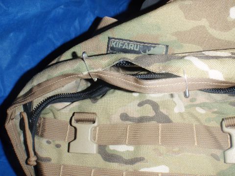 1991 Ford Bronco - A camouflage backpack with a KIFARU brand tag is shown with safety pins securing a zipper closure.
