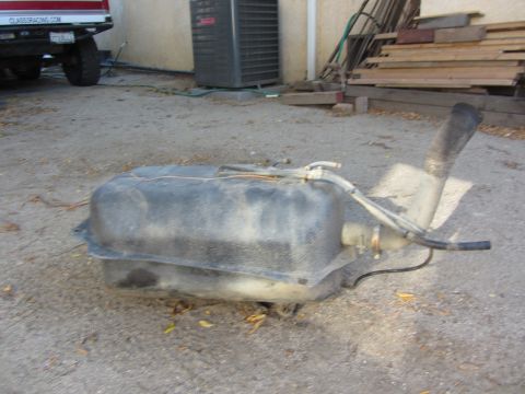1987 Suzuki Samurai - A detached vehicle fuel tank sits on the ground, showing its various hoses and filler pipe.