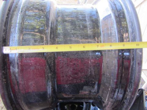 1987 Suzuki Samurai - A black wheel rim is measured with a yellow tape measure.