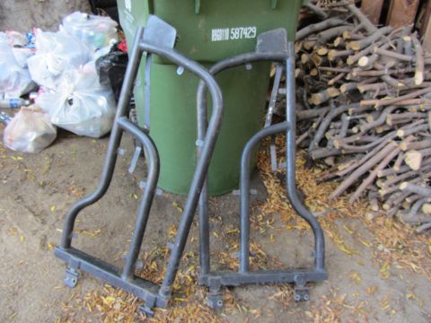 1987 Suzuki Samurai - Two metal roll cage sections are shown leaning against a green trash bin with firewood in the background.