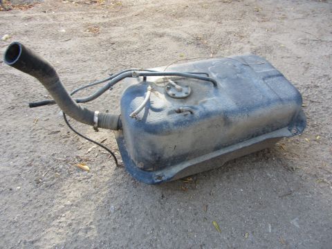 1987 Suzuki Samurai - A used vehicle fuel tank is shown outdoors, connected to its hoses and filler pipe.