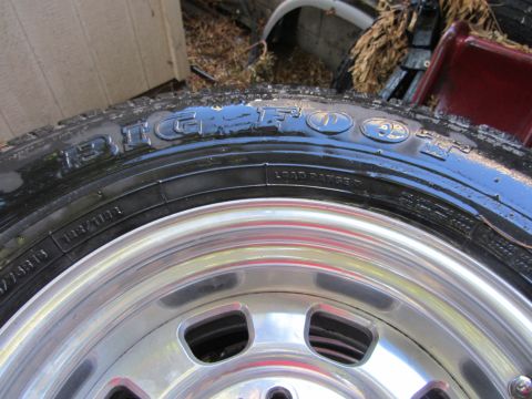 1987 Suzuki Samurai - Close-up of a Bigfoot tire mounted on a shiny chrome wheel.