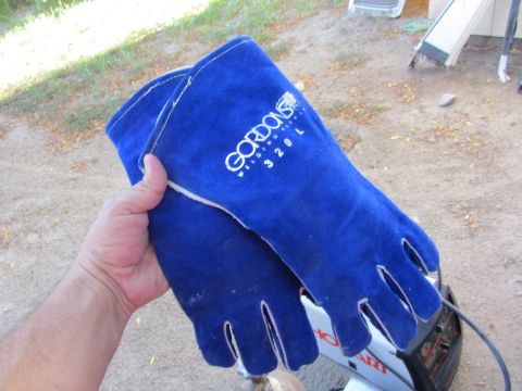 1987 Suzuki Samurai - A pair of blue Gordons Welding Supply welding gloves are held up for the camera, with a welding machine visible in the background.