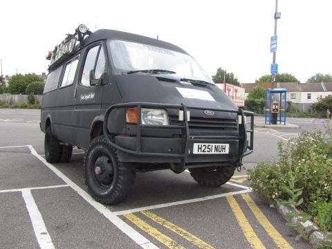 1968 Ford Mustang - This modified black van features a prominent bull bar, a roof rack, and off-road tires, suggesting it is built for challenging terrain.