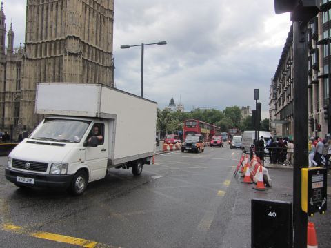 1968 Ford Mustang - A white box truck navigates a wet street in London, with iconic buildings and other traffic visible.