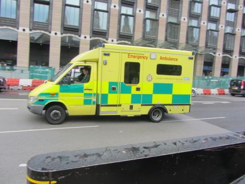 1968 Ford Mustang - An ambulance with "London Ambulance Service NHS" markings is seen driving on a city street.