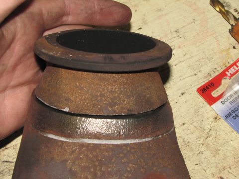 1993 Ford F-250 - Close-up view of a rusty exhaust pipe elbow, showing a black gasket and signs of wear.
