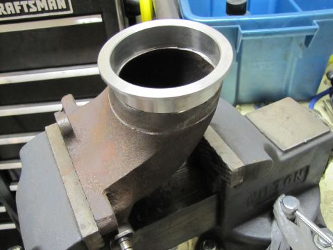 1993 Ford F-250 - A turbo elbow pipe is secured in a heavy-duty vise, ready for modification or repair.