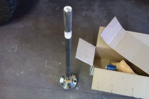 1999 Chevrolet Camaro - Axle shaft with hub assembly, likely a replacement part, beside a shipping box.