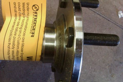1999 Chevrolet Camaro - A close-up view of a wheel hub assembly, a warning tag from Moser Engineering.