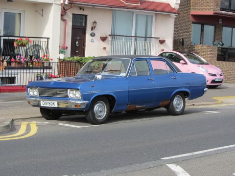 1968 Ford Mustang - A blue 1965 Vauxhall Cresta sedan is parked on a street, with a pink car visible behind it.