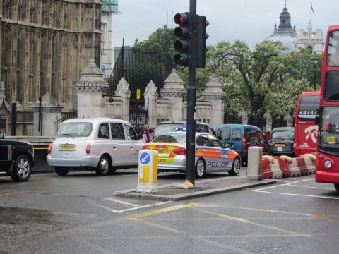 1968 Ford Mustang - A police car and a London taxi are seen in traffic near the Houses of Parliament.