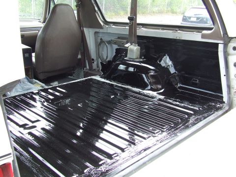 1996 Ford Bronco - The interior cargo area of a 1996 Ford Bronco shows a freshly applied black bed liner.