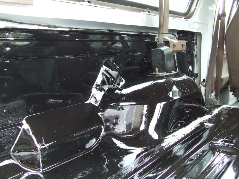 1996 Ford Bronco - The interior floor of a vehicle has been coated with a black protective material.