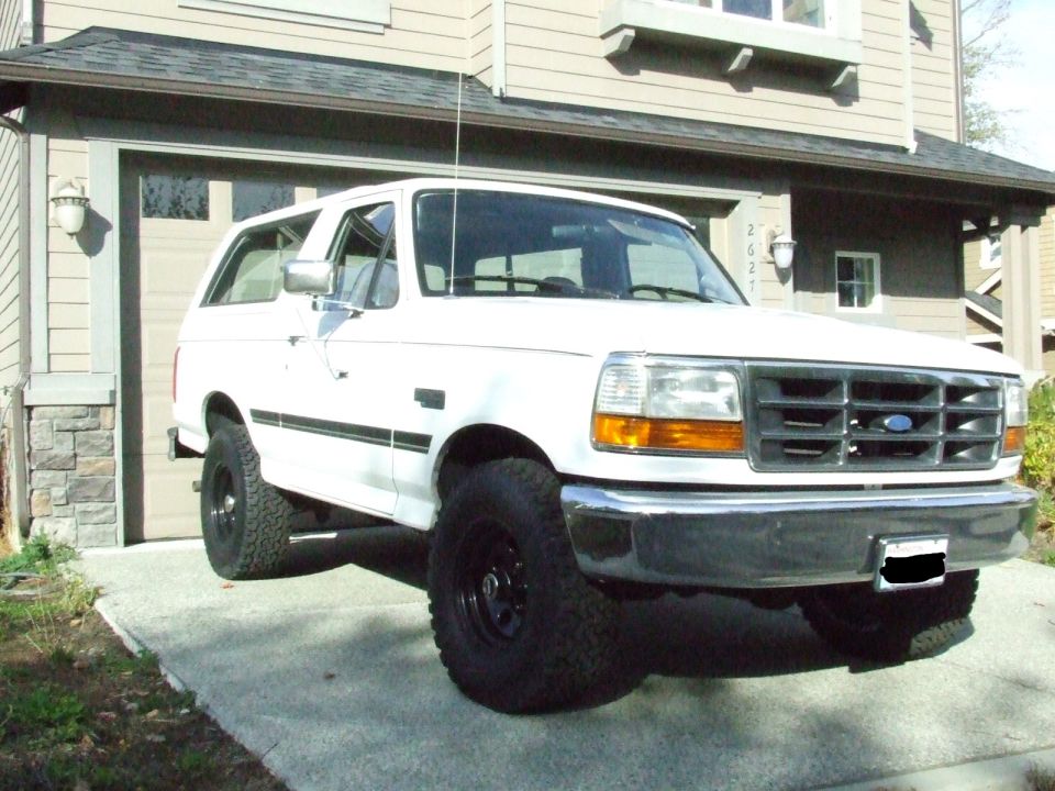 1996 Ford Bronco parked in front of a house with garage door