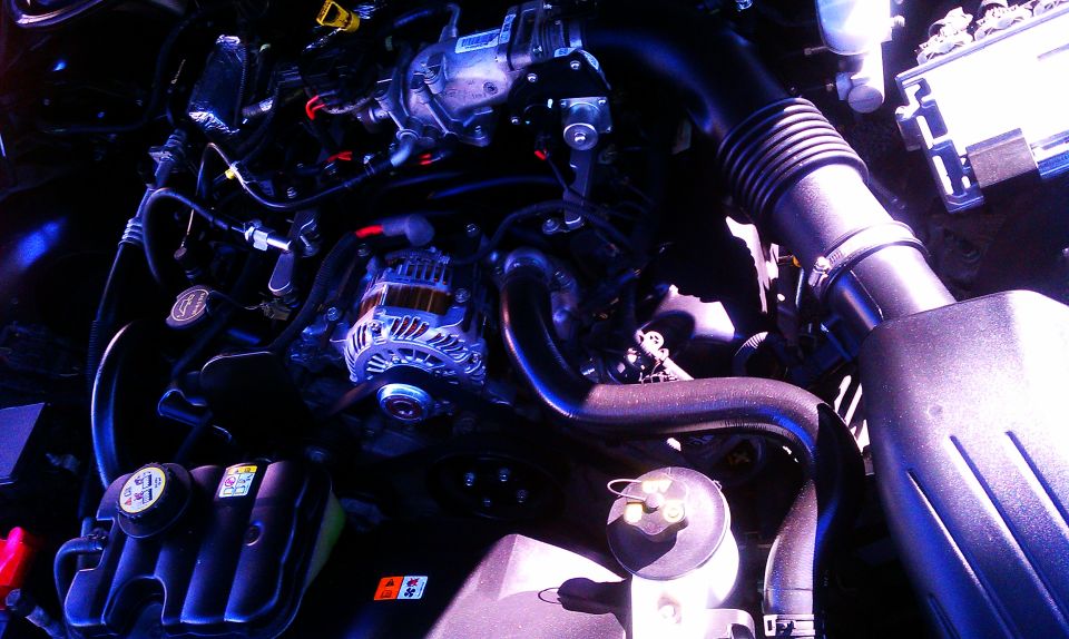 Engine bay showing alternator, intake tube, and wiring