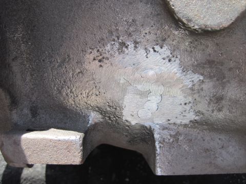 1979 Ford Bronco - Close-up view of a metal engine block casting showing grinding marks and surface texture.