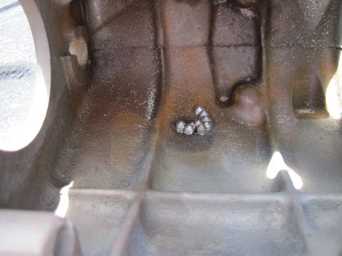1979 Ford Bronco - Close-up view of the inside of an engine block, showing casting details and some debris.