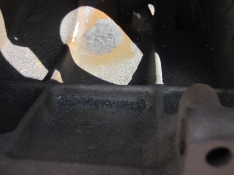 1979 Ford Bronco - Detail of an engine block casting, showing textured surfaces and metallic paint remnants.