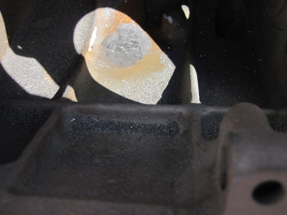 Close-up of a black engine block casting with metallic paint flecks