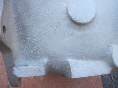 1979 Ford Bronco - Cast metal engine component with visible mounting points and textured surface.
