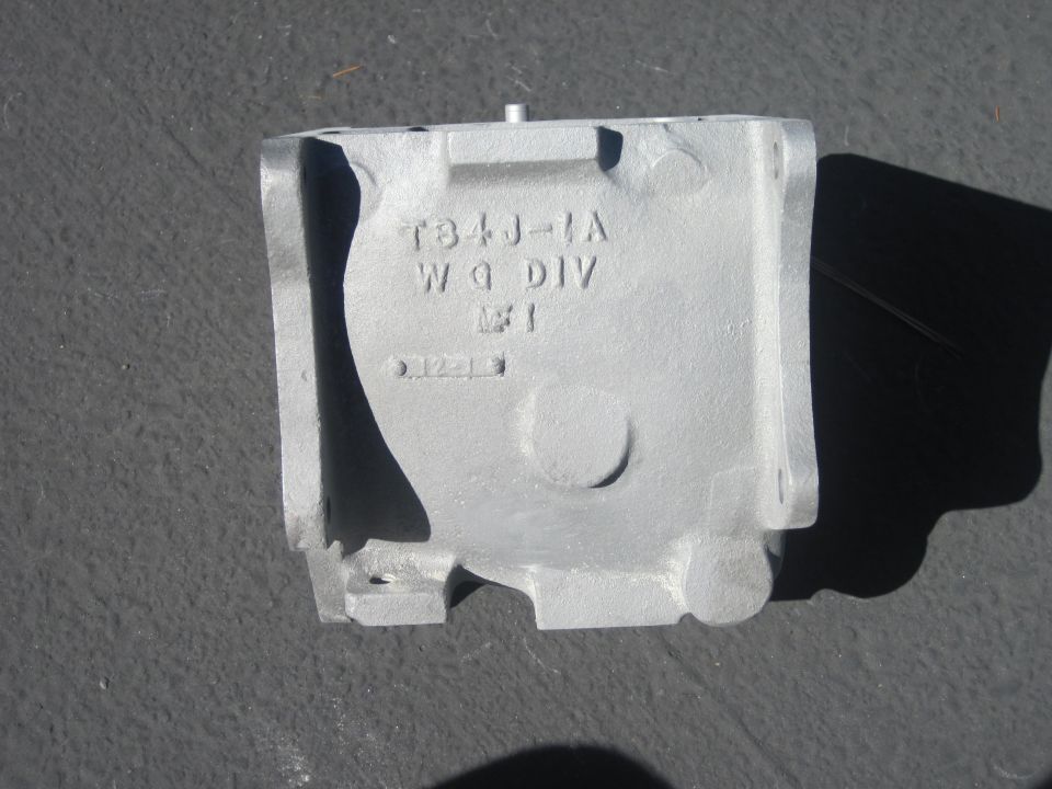 Gray metal casting with text T84J-1A WQ DIV W1 012-13