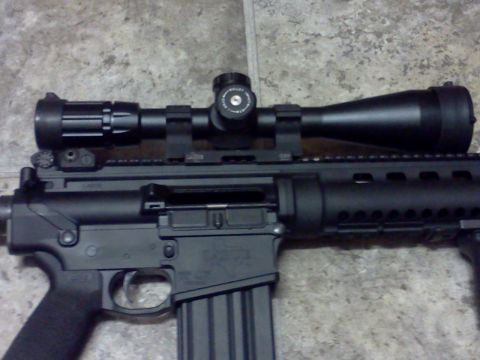 1996 Ford Bronco - This image shows a rifle equipped with a telescopic sight, resting on a textured surface.
