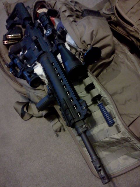 1996 Ford Bronco - A tactical rifle with a scope and bipod rests on a large, open bag.