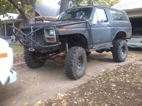 1986 Ford Bronco - This heavily modified Ford Bronco features oversized tires and a exterior, suggesting off-road capabilities.