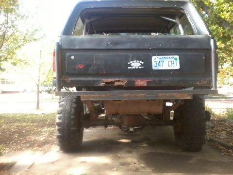 1986 Ford Bronco - Rear view of a black Ford Bronco with significant rust and modifications.