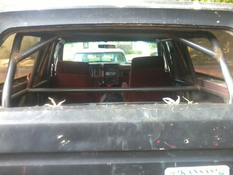 1986 Ford Bronco - View of the interior and dashboard of a modified SUV, with another vehicle seen through the windshield.