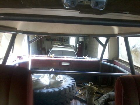 1986 Ford Bronco - View from inside a modified vehicle, looking out at another vehicle in a garage.