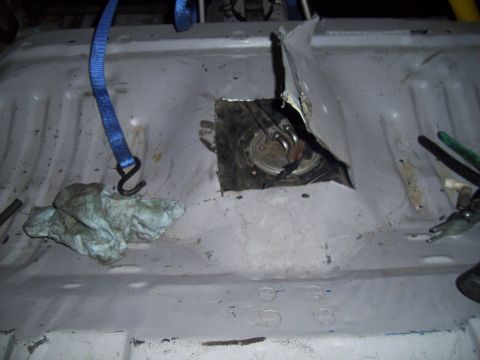 1995 Ford Probe - Access panel cut into the vehicle's floor reveals the fuel pump assembly for maintenance.