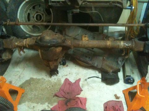 1992 Jeep YJ - Close-up of a heavily rusted vehicle axle and suspension parts, suggesting a project vehicle or parts salvage.