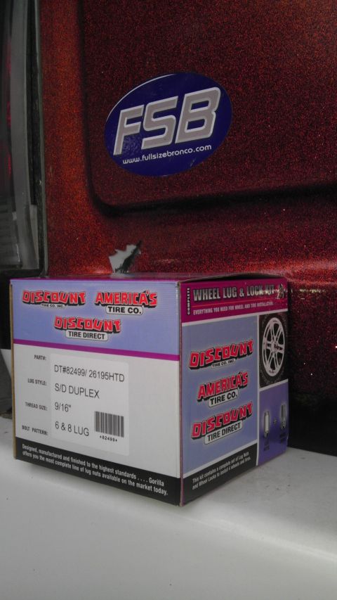 1989 Ford Bronco - A red Ford Bronco's rear quarter panel is visible with a Discount Tire Co. box in front.