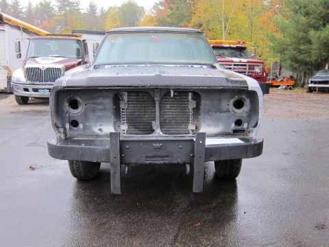 1987 Dodge 1500 - Front view of a 1987 Dodge 1500 undergoing repair, with other vehicles in the background.