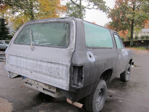 1987 Dodge 1500 - Rear view of a Dodge Ramcharger in primer, showing body damage and missing parts.
