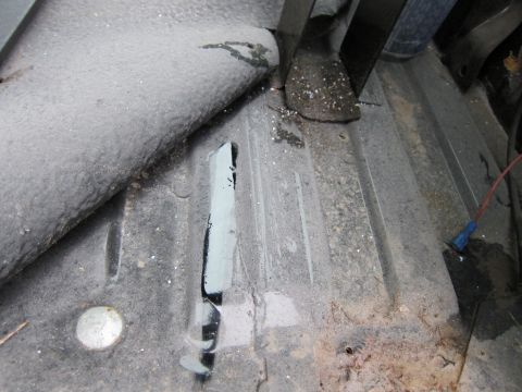 1987 Dodge 1500 - Close-up view of the interior floor pan, showing signs of rust and wear.