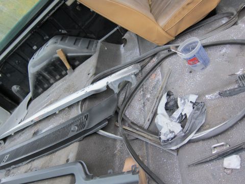 1987 Dodge 1500 - Disassembled interior parts are scattered around the cabin, with a tan seat visible in the background.