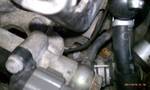 1994 Ford Probe - A close-up view of various engine components, including hoses and metal parts.