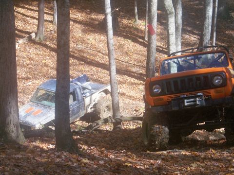 1989 Ford Bronco - Two off-road vehicles navigate a wooded trail during the fall season.