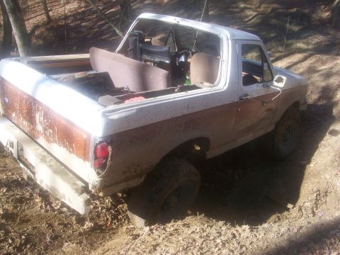 1989 Ford Bronco - This 1989 Ford Bronco appears to be in a muddy, wooded area, possibly after off-roading.