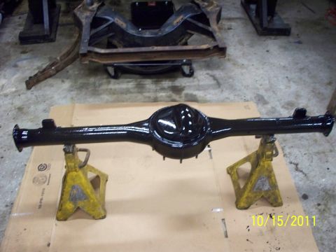 1990 Ford Bronco - Rear axle assembly painted black and supported by jack stands in a workshop.