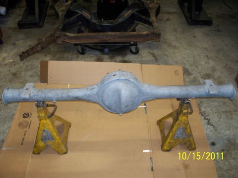 1990 Ford Bronco - A rear axle assembly is shown on jack stands, with a vehicle frame visible behind it.