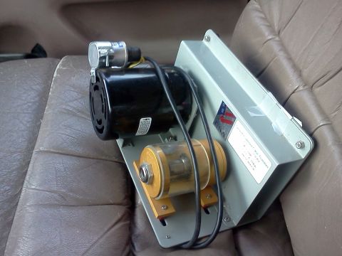 1996 Ford Bronco - An electrical assembly with a motor and a clear filter sits on a vehicle's leather seat.