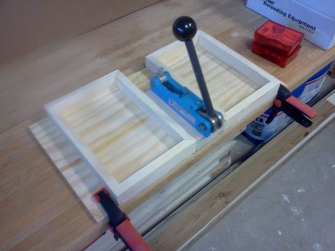1996 Ford Bronco - A blue reloading press with a black handle is clamped to a wooden workbench, with reloading equipment boxes in the background.