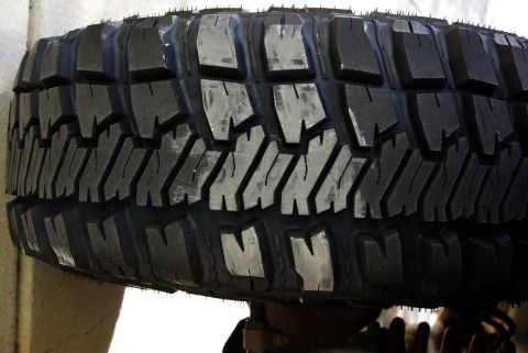 1995 Ford Bronco - A detailed view of a tire, showing its aggressive tread pattern and white paint marks.