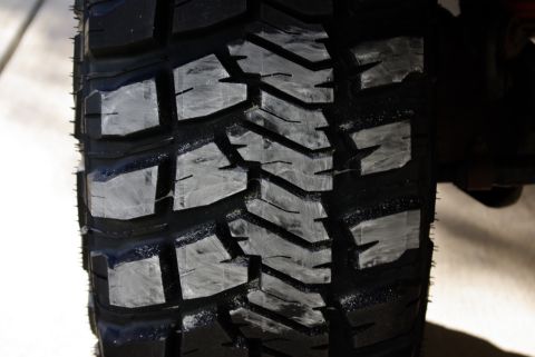 1995 Ford Bronco - Detail of a tire's aggressive tread pattern, marked with white paint.